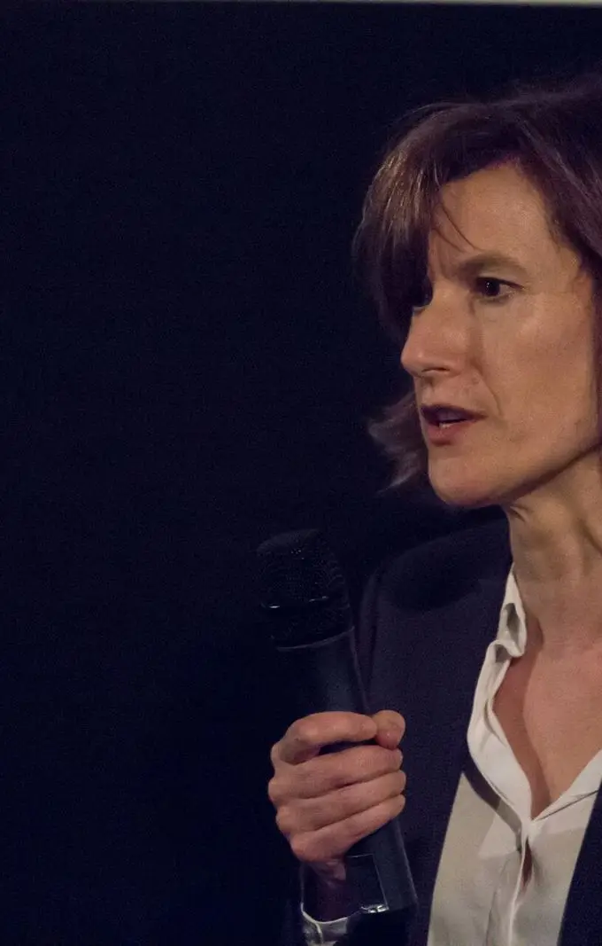 Film director Joanna Hogg, as identified in the source file, speaking with a microphone on a darkened stage at a film event. File photograph from an earlier appearance, not from the El Gouna festival.