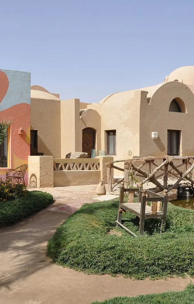 File photo of El Gouna: domed sand- and ochre-coloured resort buildings with an art gallery, planted gardens and a wooden footbridge over a small waterway. Not a photograph taken during the film festival.